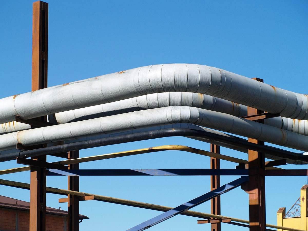 Des tuyaux blancs sur une structure métallique sous un ciel bleu Des tuyaux blancs sur une structure métallique sous un ciel bleu