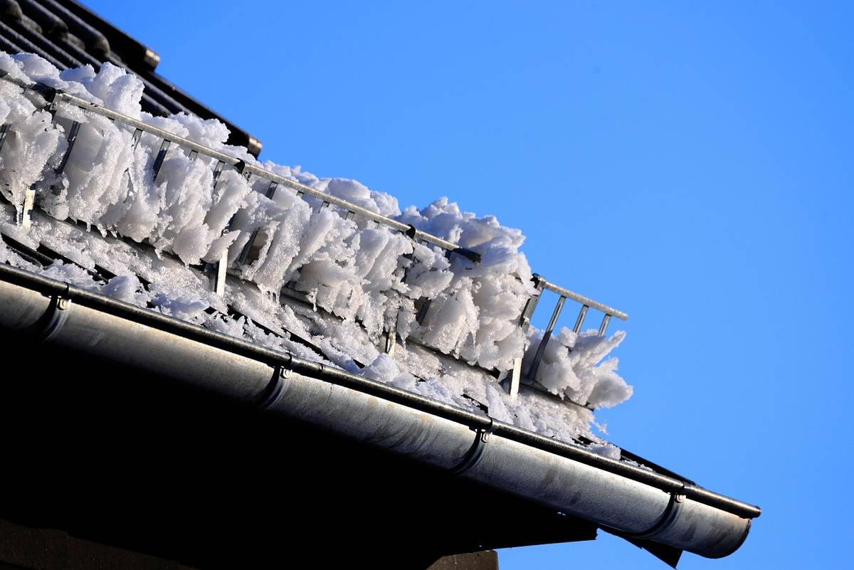 Des stalactites de glace pendent sous la gouttière du toit
