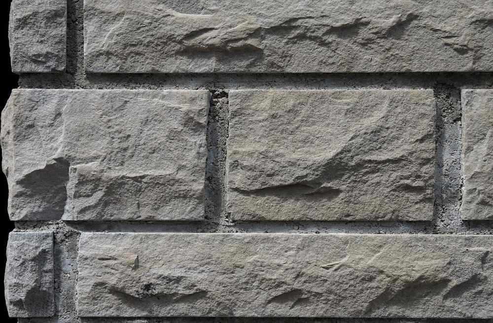 Gros plan sur mur de pierre taillée avec joints de mortier entre les blocs