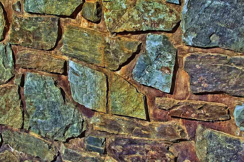 Mur de pierres de différentes couleurs avec joints de mortier